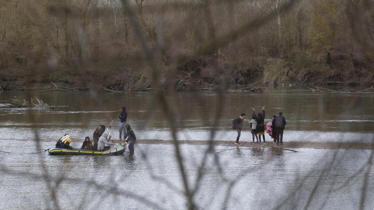 Migranten haben in einem Schlauchboot den Fluss Meric zwischen der Türkei und Griechenland überquert und gehen gerade an Land. Migranten haben in einem Schlauchboot den Fluss Meric zwischen der Türkei und Griechenland überquert und gehen gerade an Land.