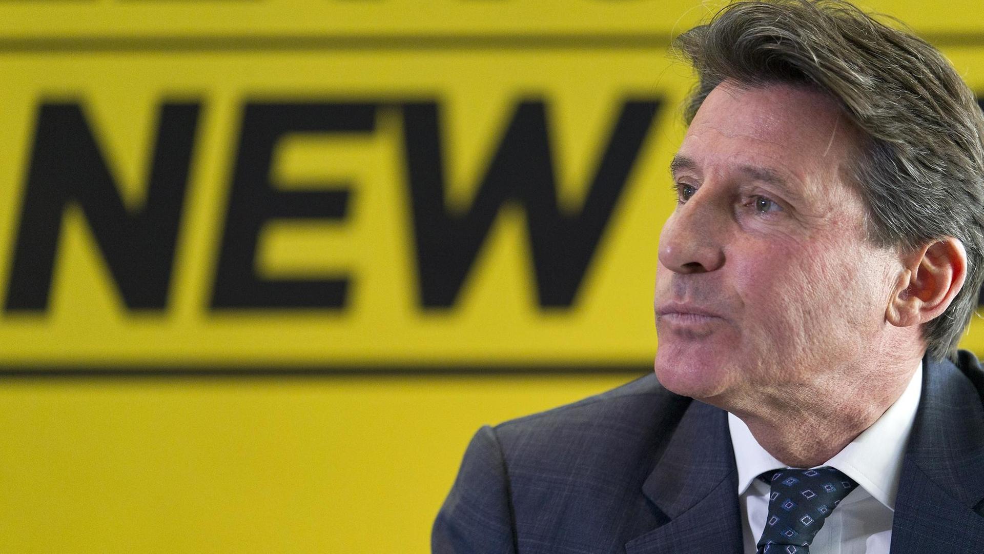 Sebastian Coe im Profil, vor einer gelben Wand, auf der das Wort "New" geschrieben steht. Sebastian Coe im Profil, vor einer gelben Wand, auf der das Wort "New" geschrieben steht.