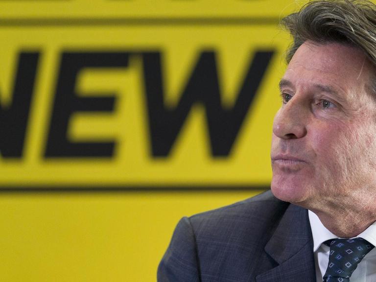 Sebastian Coe im Profil, vor einer gelben Wand, auf der das Wort "New" geschrieben steht.