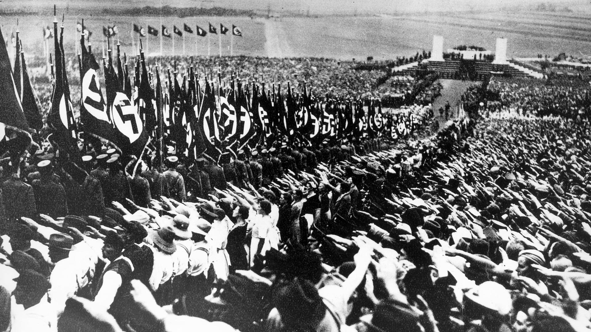 Massenveranstaltung während der NS-Diktatur: Die Bevölkerung mit zum Hitlergruß erhobenem rechten Arm beim Aufmarsch der Fahnen während einer Erntedankfeier auf dem Bückeberg bei Hameln (undatiert) Massenveranstaltung während der NS-Diktatur: Die Bevölkerung mit zum Hitlergruß erhobenem rechten Arm beim Aufmarsch der Fahnen während einer Erntedankfeier auf dem Bückeberg bei Hameln (undatiert)