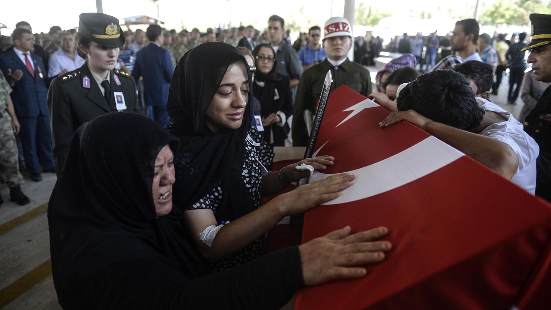 Die Ehefrau des türkischen Soldaten Mehmet Yalcin Nane trauert am Sarg ihres Mannes, der an der türkisch-syrischen Grenze getötet wurde. Die Ehefrau des türkischen Soldaten Mehmet Yalcin Nane trauert am Sarg ihres Mannes, der an der türkisch-syrischen Grenze getötet wurde.