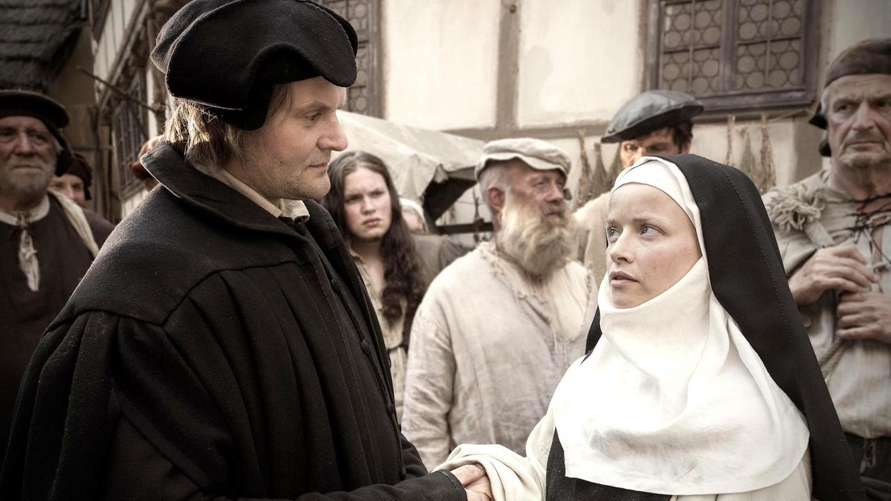 Szene aus dem Film "Katharina Luther". Katharina und die anderen geflohenen Nonnen kommen in Wittenberg an. Luther begrüßt Katharina.