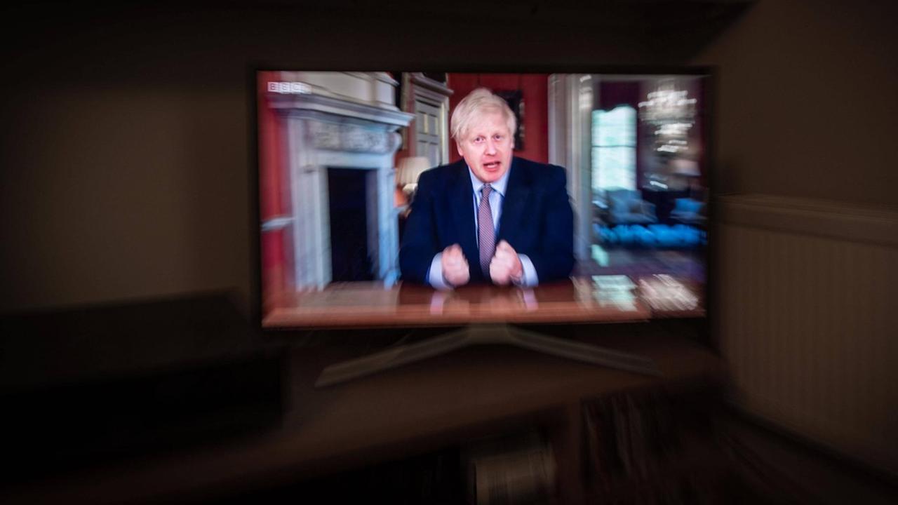 Der britische Premierminister Boris Johnson ist während einer Ansprache auf einem Fernsehbildschirm zu sehen. Der britische Premierminister Boris Johnson ist während einer Ansprache auf einem Fernsehbildschirm zu sehen.