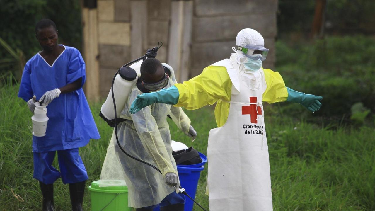 Ein Helfer in einem Ebola-Zentrum in Beni, Ostkongo, wird mit Desinfektionsmittel besprüht.