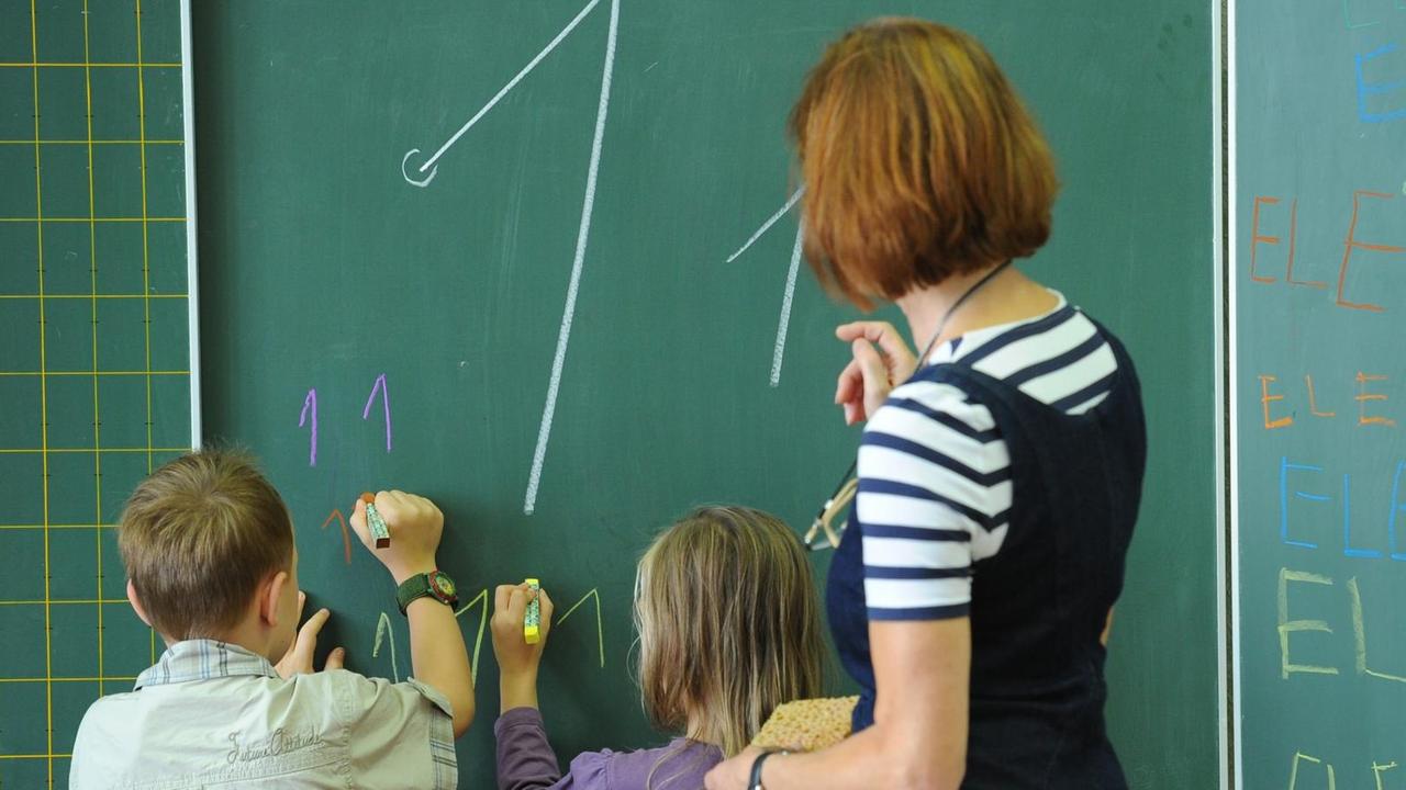 Ein rechtshändiger Junge und ein linkshändiges Mädchen der 1. Klasse der Goethe-Grundschule in Potsdam üben am Montag (22.08.2011) im Unterricht unter Anleitung der Klassenlehrerin das Schreiben der "Eins" an der Tafel. Ein rechtshändiger Junge und ein linkshändiges Mädchen der 1. Klasse der Goethe-Grundschule in Potsdam üben am Montag (22.08.2011) im Unterricht unter Anleitung der Klassenlehrerin das Schreiben der "Eins" an der Tafel.