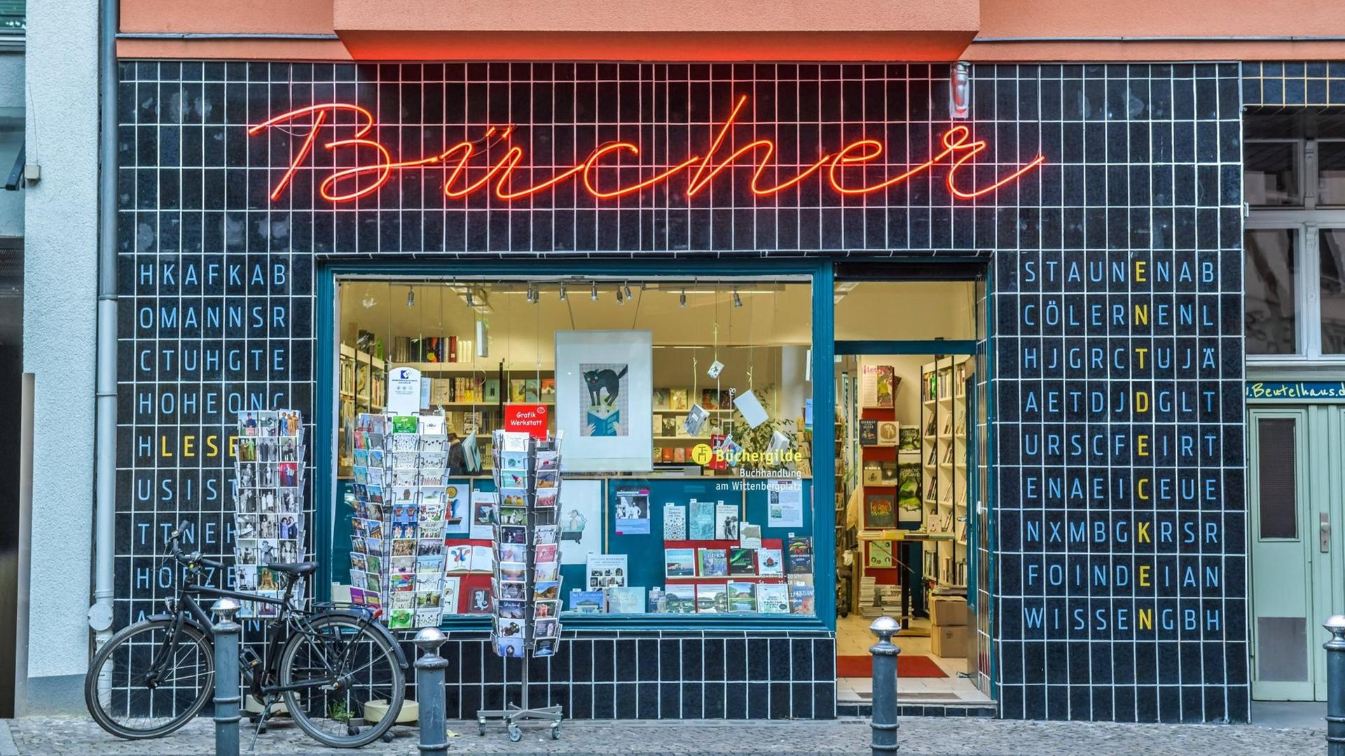 Blick auf die Fassade eines Buchladens — der Schriftzug Bücher steht als Leuchtschrift an der Wand