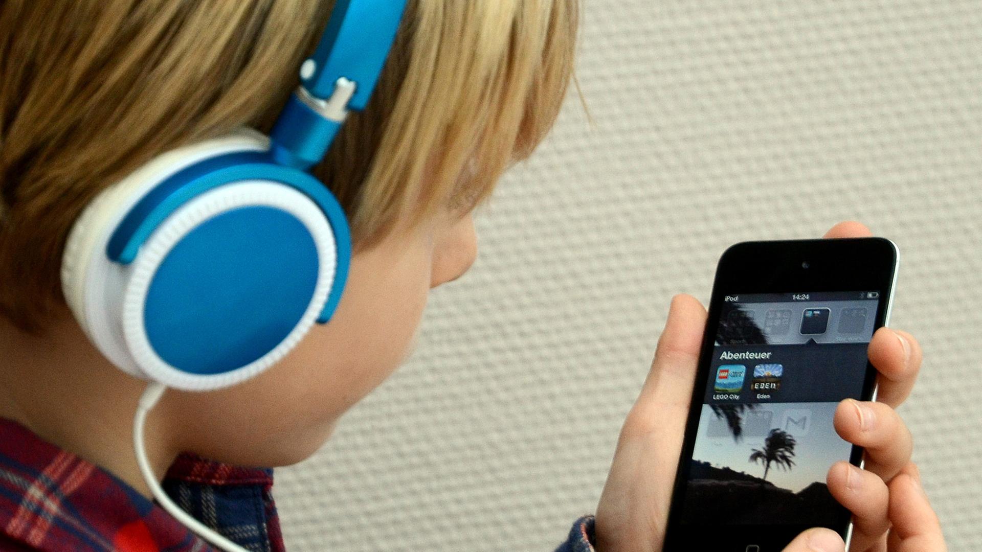 Ein Kind hört Musik mit seinem iPod von Apple. Ein Kind hört Musik mit seinem iPod von Apple.