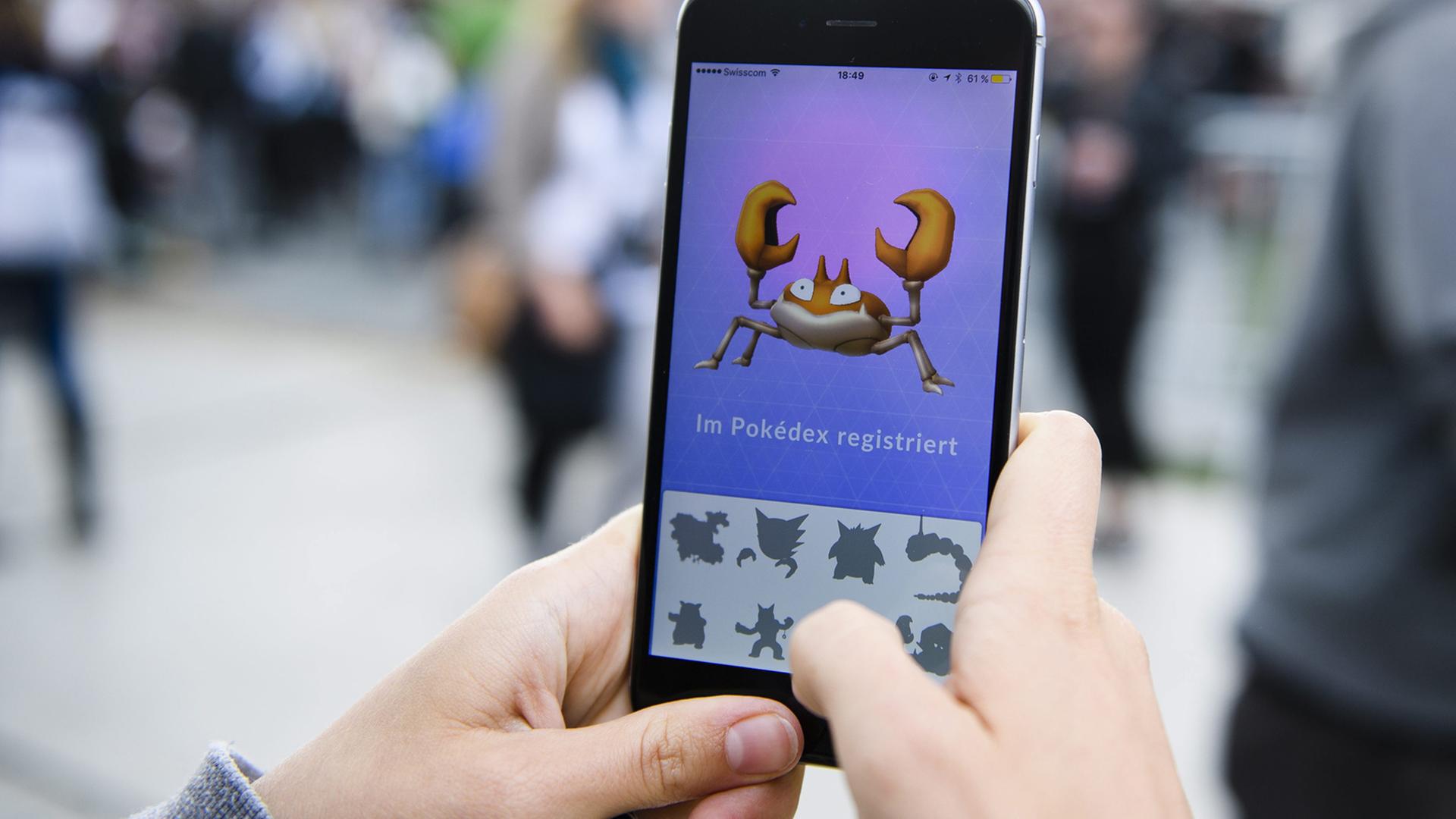 Eine Frau spielt auf ihrem Smartphone Pokémon Go. Eine Frau spielt auf ihrem Smartphone Pokémon Go.