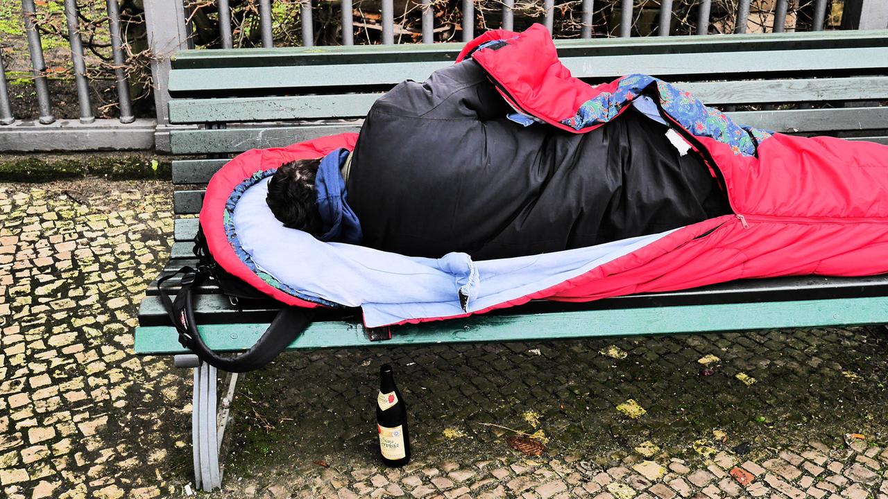 Obdachloser schläft auf einer Parkbank in Berlin-Mitte