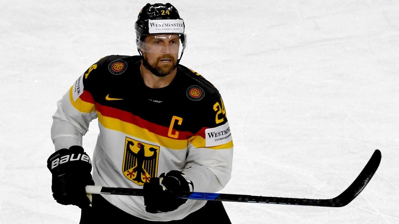 Seidenberg mit konzentriertem Blick auf dem Eis, den Schläger einsatzbereit in die Höhe haltend. Seidenberg mit konzentriertem Blick auf dem Eis, den Schläger einsatzbereit in die Höhe haltend.