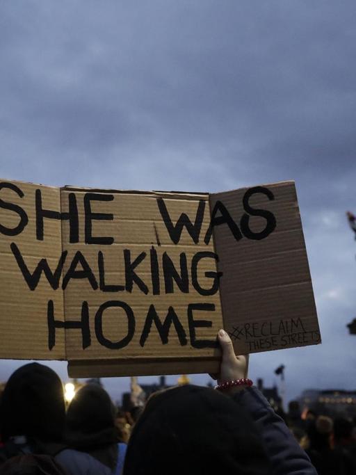 Demonstranten vor dem Londoner Parlament mit einem Schild "She was walking home"; Übersetzung: "Sie ging nach Hause".
