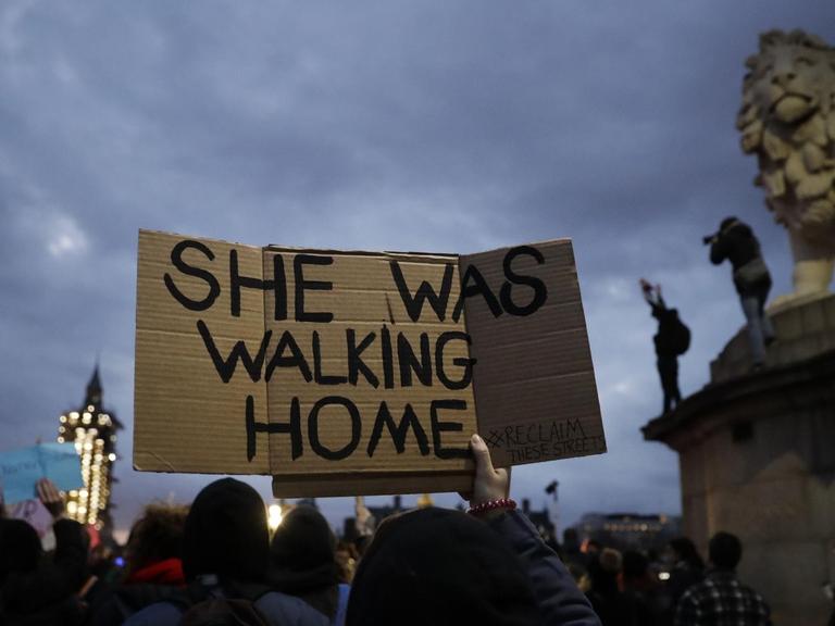 Demonstranten vor dem Londoner Parlament mit einem Schild "She was walking home"; Übersetzung: "Sie ging nach Hause".