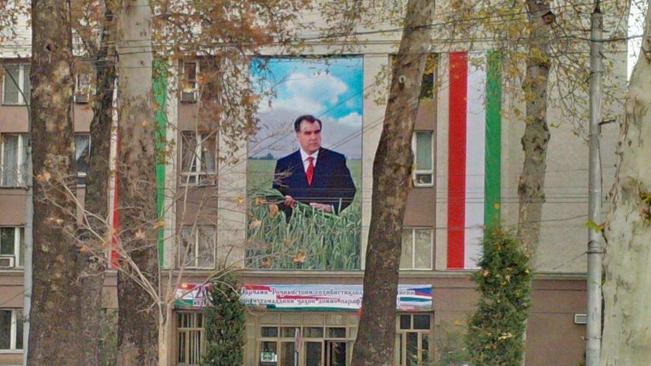 Ein Plakat mit dem Konterfei von Staatspräsident Emomalii Rahmon hängt an einem Gebäude.