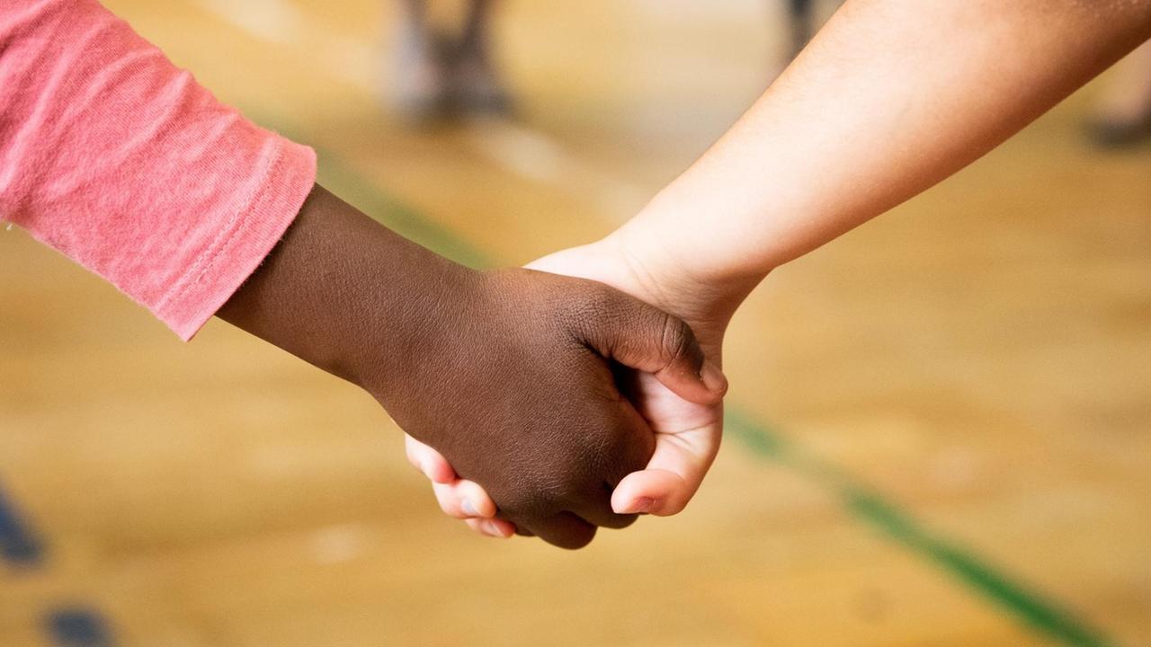 Zwei Kinder halten sich an der Hand Zwei Kinder halten sich an der Hand