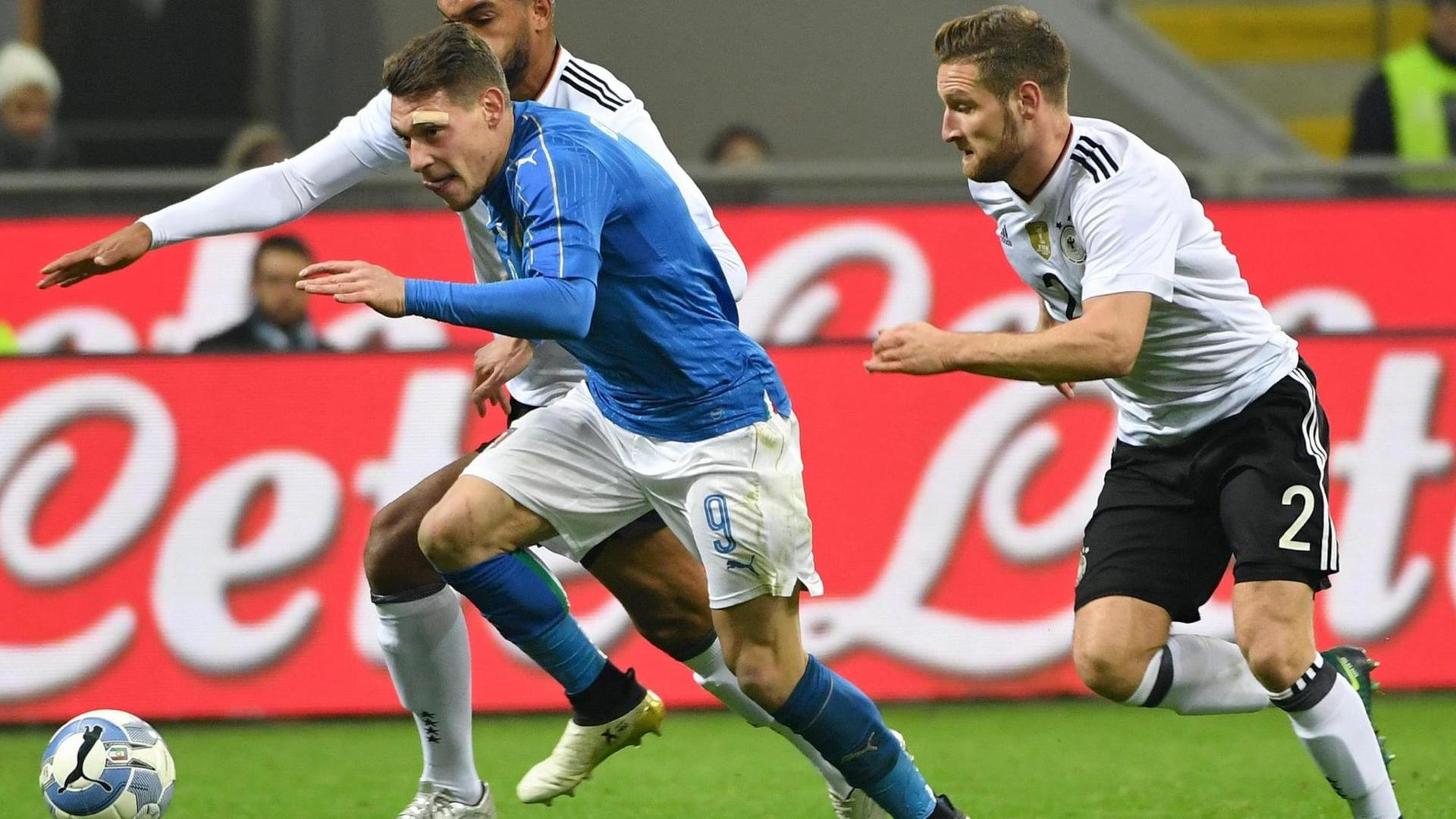 Sie sehen die Spieler Andrea Belotti aus Italien und die deutschen Spieler Shkodran Mustafi (rechts) und Jonathan Tah (links). Sie sehen die Spieler Andrea Belotti aus Italien und die deutschen Spieler Shkodran Mustafi (rechts) und Jonathan Tah (links).