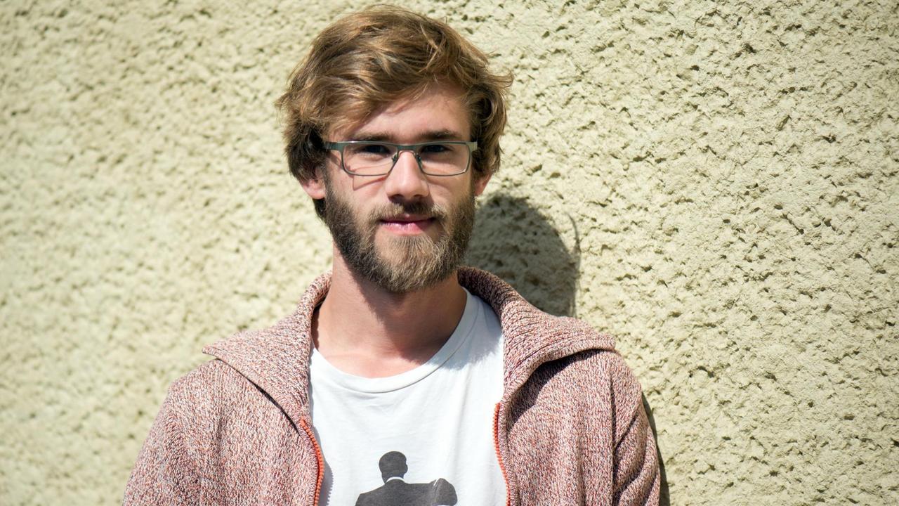 Alexej Hock steht vor einer hellgelben Wand. Alexej Hock steht vor einer hellgelben Wand.