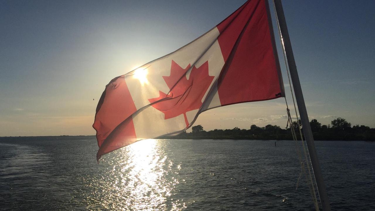 Die kanadische Flagge weht auf einem Expeditionsschiff, das entlag der kanadischen Küste fährt.