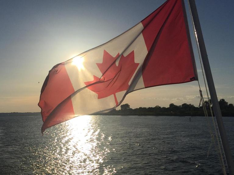 Die kanadische Flagge weht auf einem Expeditionsschiff, das entlag der kanadischen Küste fährt.