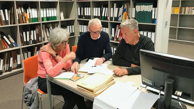Zwei Männer und eine Frau sitzen an einem Tisch im Landesarchiv Brandenburg und studieren Akten. Zwei Männer und eine Frau sitzen an einem Tisch im Landesarchiv Brandenburg und studieren Akten.