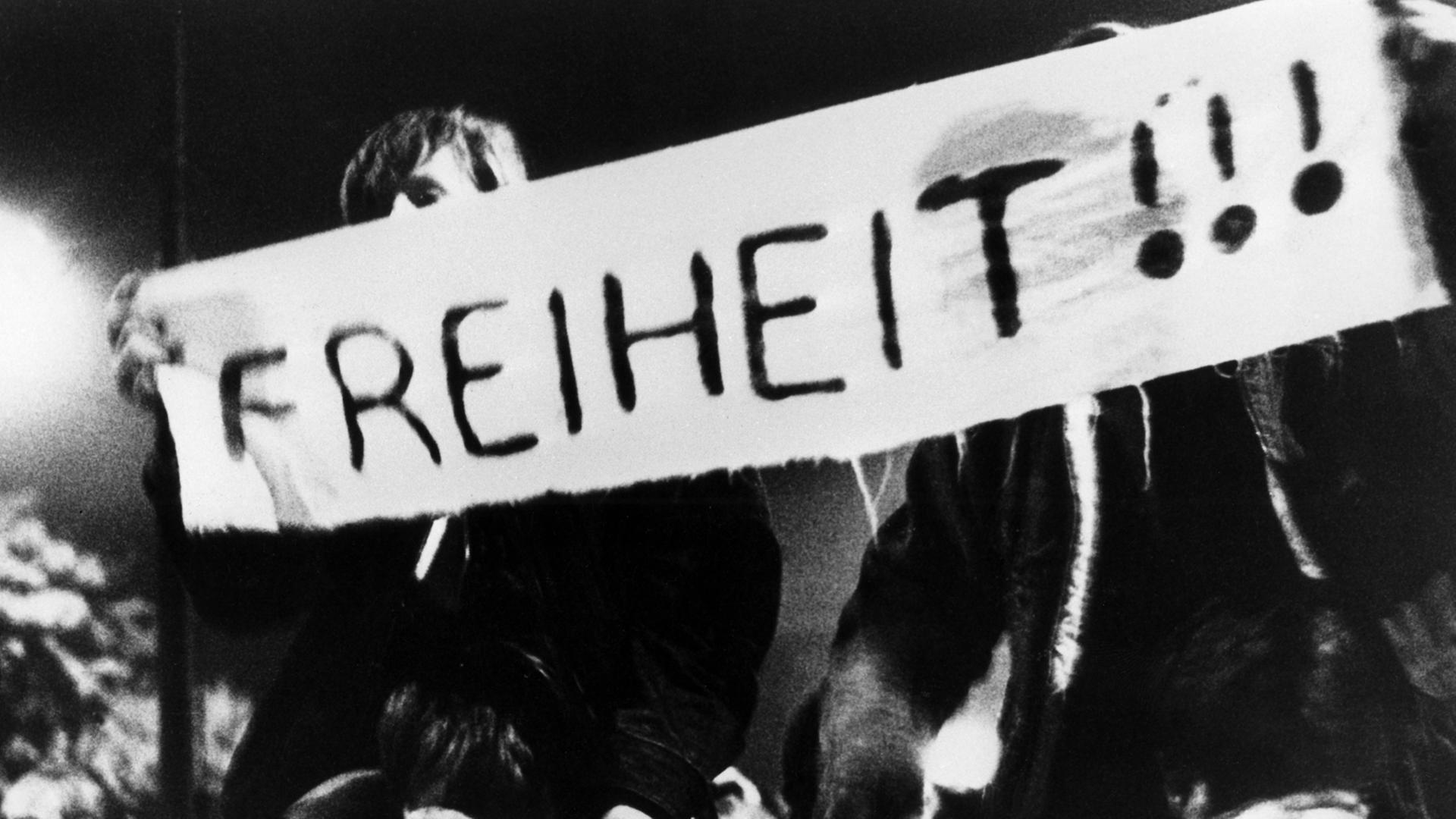 Auf Transparenten fordern Teilnehmer des friedlichen Demonstrationszuges am 10.10.1989 durch die Leipziger Innenstadt immer wieder "Freiheit" - hier auf einem Banner mit drei Ausrufungszeichen zu lesen.