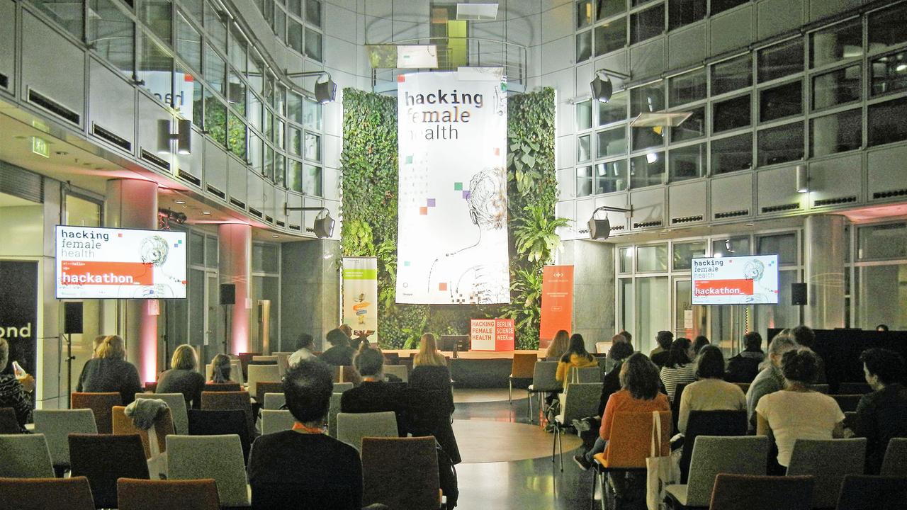 Blick aus den Zuschauerreihen zum Podium des Hackathon zum Thema Frauengesundheit im Rahmen der Science Week Blick aus den Zuschauerreihen zum Podium des Hackathon zum Thema Frauengesundheit im Rahmen der Science Week