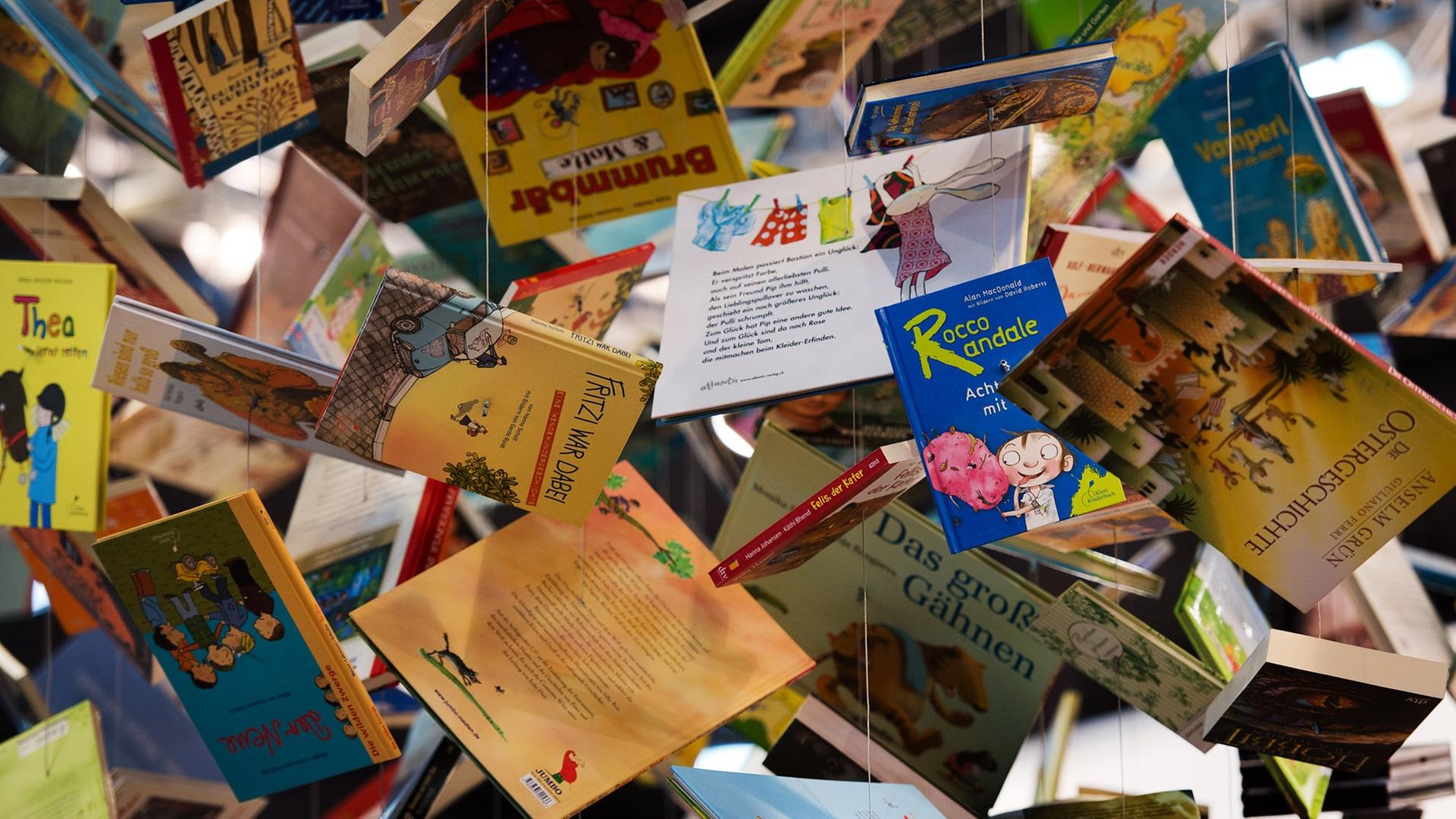 An der Decke über dem Stand der Kooperation Kinder- und Jugendbuch des Deutschen Taschenbuch Verlages (dtv) hängen am 14.03.2014 auf der Leipziger Buchmesse in Leipzig (Sachsen) Bücher an Fäden. An der Decke über dem Stand der Kooperation Kinder- und Jugendbuch des Deutschen Taschenbuch Verlages (dtv) hängen am 14.03.2014 auf der Leipziger Buchmesse in Leipzig (Sachsen) Bücher an Fäden.