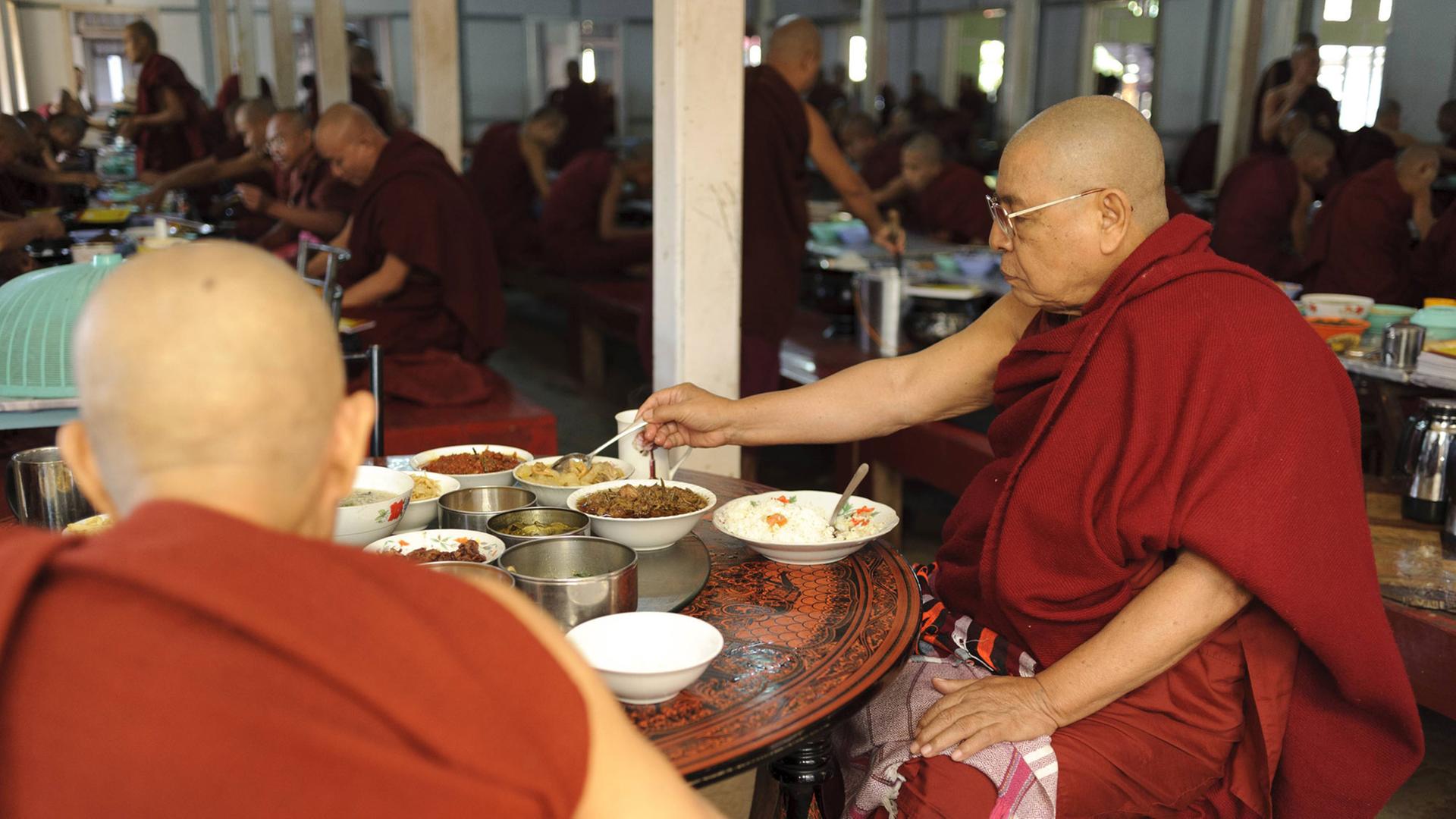 Buddhistische Mönche bei der Mönchsspeisung in einem Kloster in Myanmar Buddhistische Mönche bei der Mönchsspeisung in einem Kloster in Myanmar