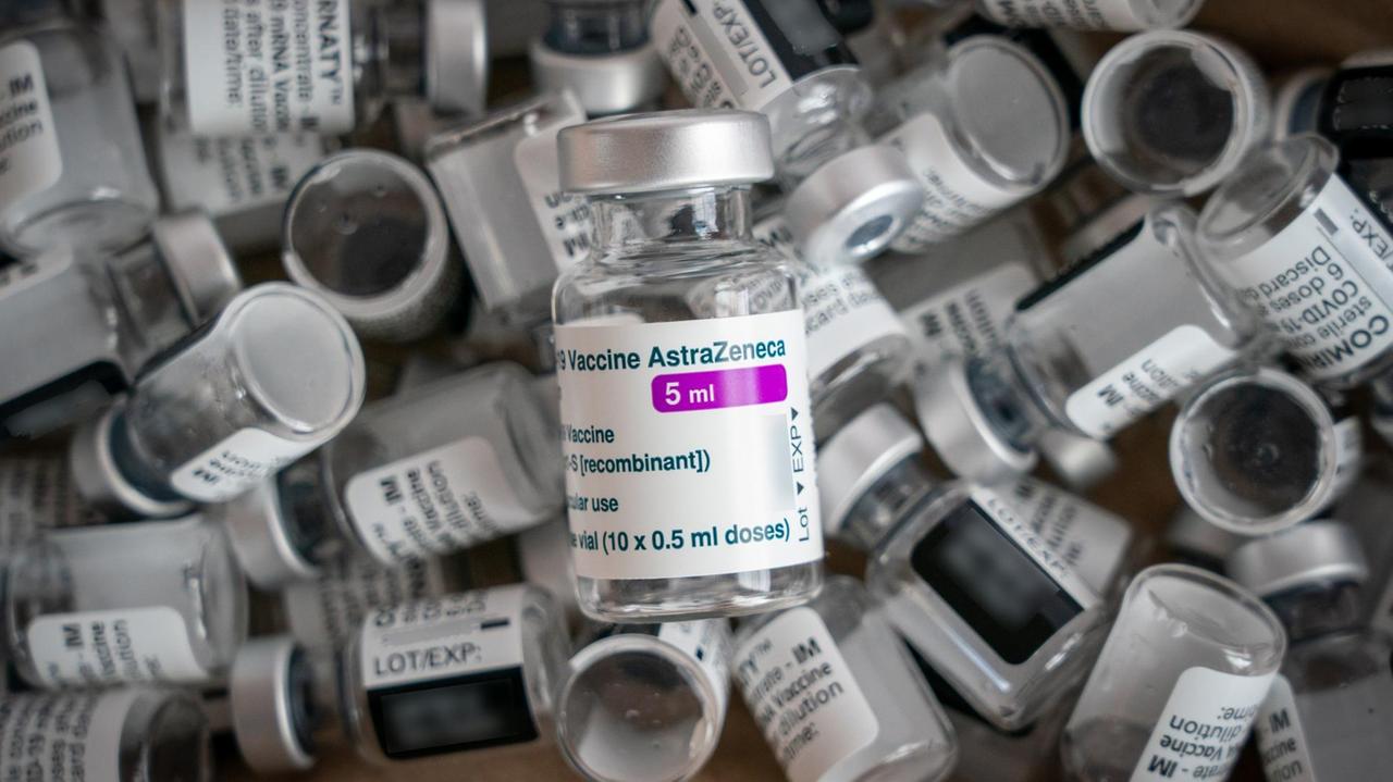 Eine leere Impfampulle der Firma AstraZeneca liegt auf leeren Ampullen der Firma Biontech/Pfizer (Comirnaty). Eine leere Impfampulle der Firma AstraZeneca liegt auf leeren Ampullen der Firma Biontech/Pfizer (Comirnaty).