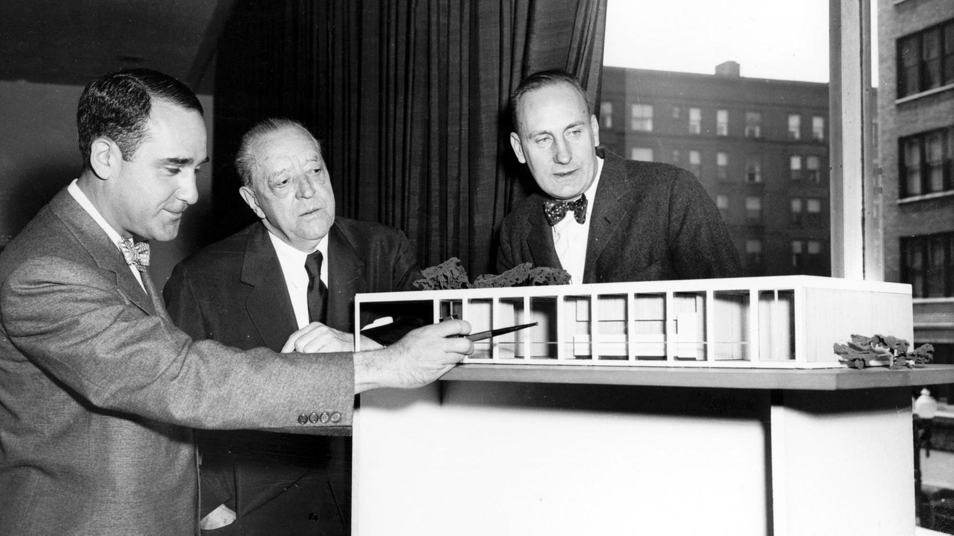 Der Architekt Ludwig Mies van der Rohe (M) mit Herbert S. Greenwald (l) und Robert H. McCormick jr. (r) vor dem Modell eines von ihm entworfenen und in Chicago gebauten Hauses aus Glas und Stahl (undatiert). Der Architekt Ludwig Mies van der Rohe (M) mit Herbert S. Greenwald (l) und Robert H. McCormick jr. (r) vor dem Modell eines von ihm entworfenen und in Chicago gebauten Hauses aus Glas und Stahl (undatiert).