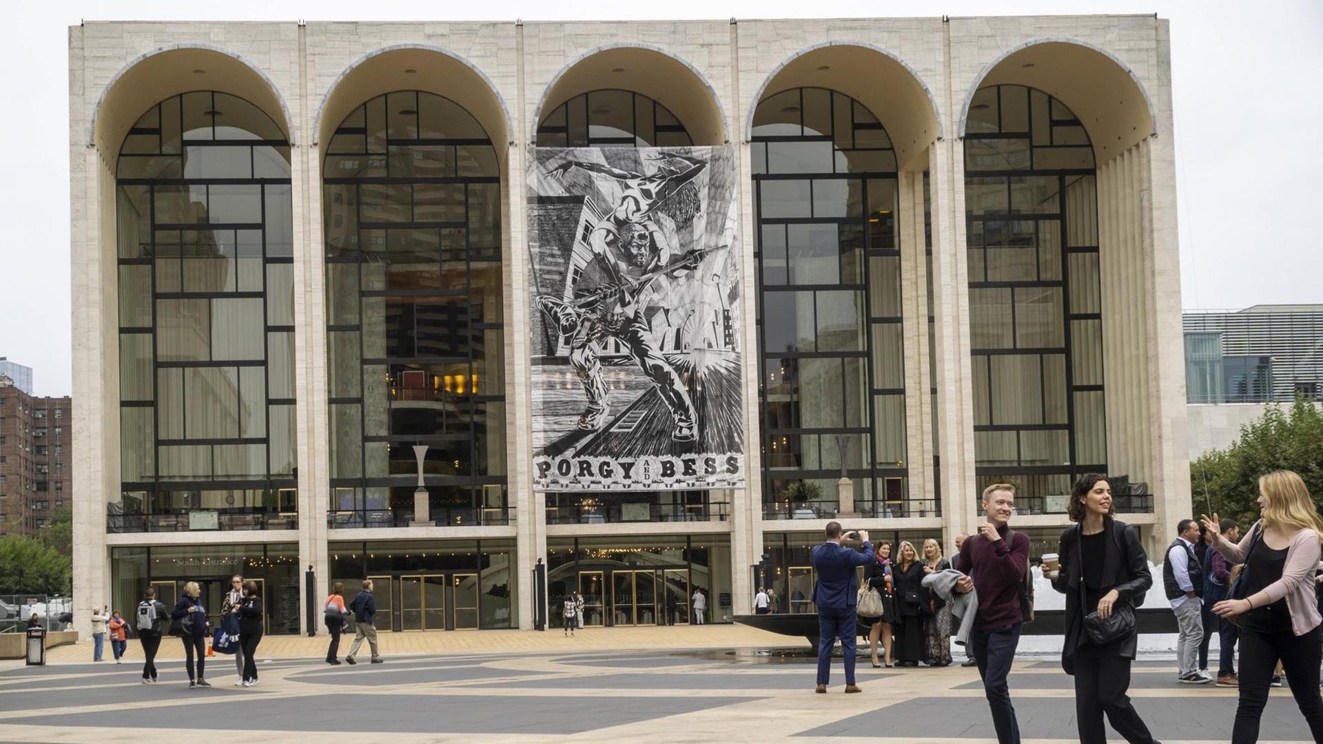 Menschen laufen vor dem MET in New York City – einem kubusförmigen Gebäude mit fünf großen, halbrunden Fesnterfronten. Menschen laufen vor dem MET in New York City – einem kubusförmigen Gebäude mit fünf großen, halbrunden Fesnterfronten.