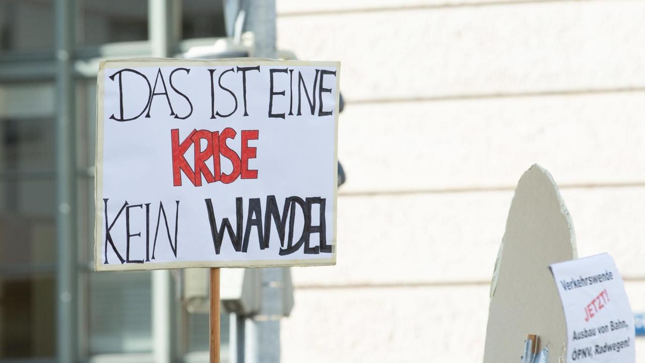 Ein Teilnehmer der "Munich For Future"-Demonstration am 21. Juli 2019 hält ein Plakat mit der Aufschrift "Das ist eine Krise - kein Wandel" hoch . Ein Teilnehmer der "Munich For Future"-Demonstration am 21. Juli 2019 hält ein Plakat mit der Aufschrift "Das ist eine Krise - kein Wandel" hoch .