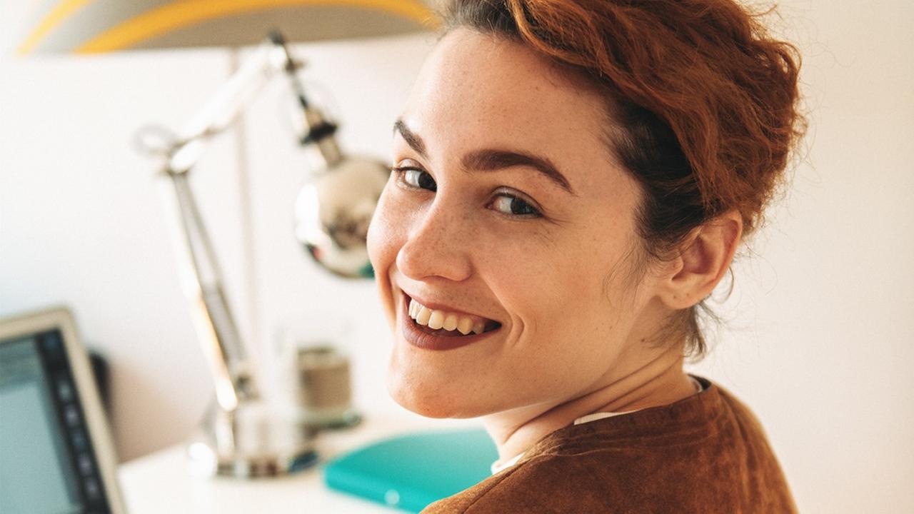 Bianca Jankovska, Autorin von "Das Millennial-Manifest", lacht über ihre Schulter in die Kamera, während sie vor einem Laptop an einem Schreibtisch sitzt. Bianca Jankovska, Autorin von "Das Millennial-Manifest", lacht über ihre Schulter in die Kamera, während sie vor einem Laptop an einem Schreibtisch sitzt.