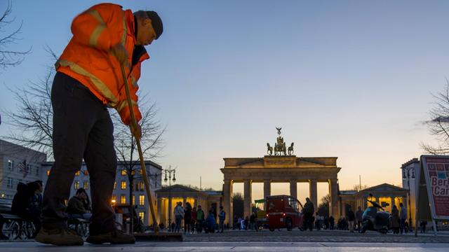 Ein Mann reinigt den Ausgang des U-Bahnhofes Brandenburger Tor in Berlin.