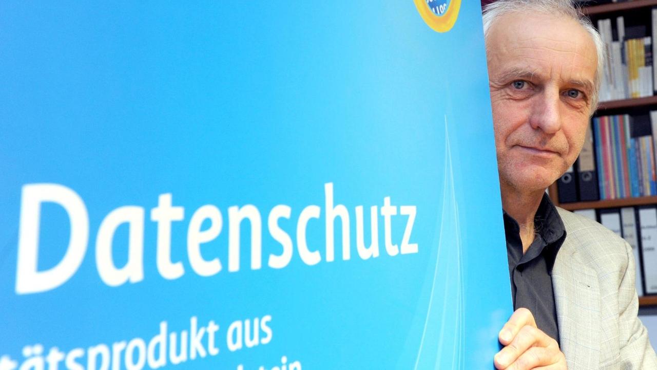 Thilo Weichert hinter einem Banner mit der Aufschrift Datenschutz
