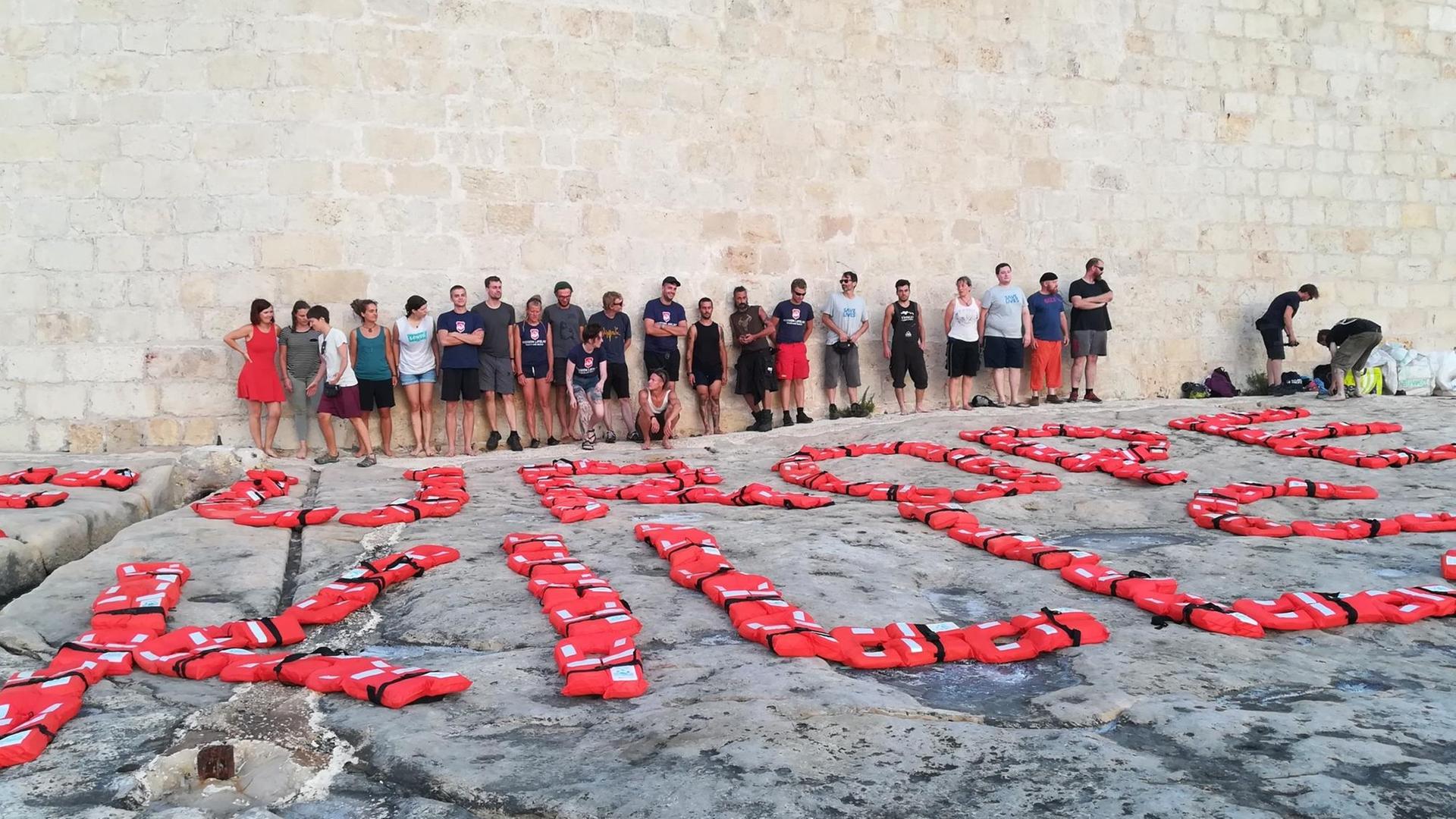 "Europe kills" haben die Crews der NGO-Boote mit Rettungswesten ans Ufer von Valletta gelegt