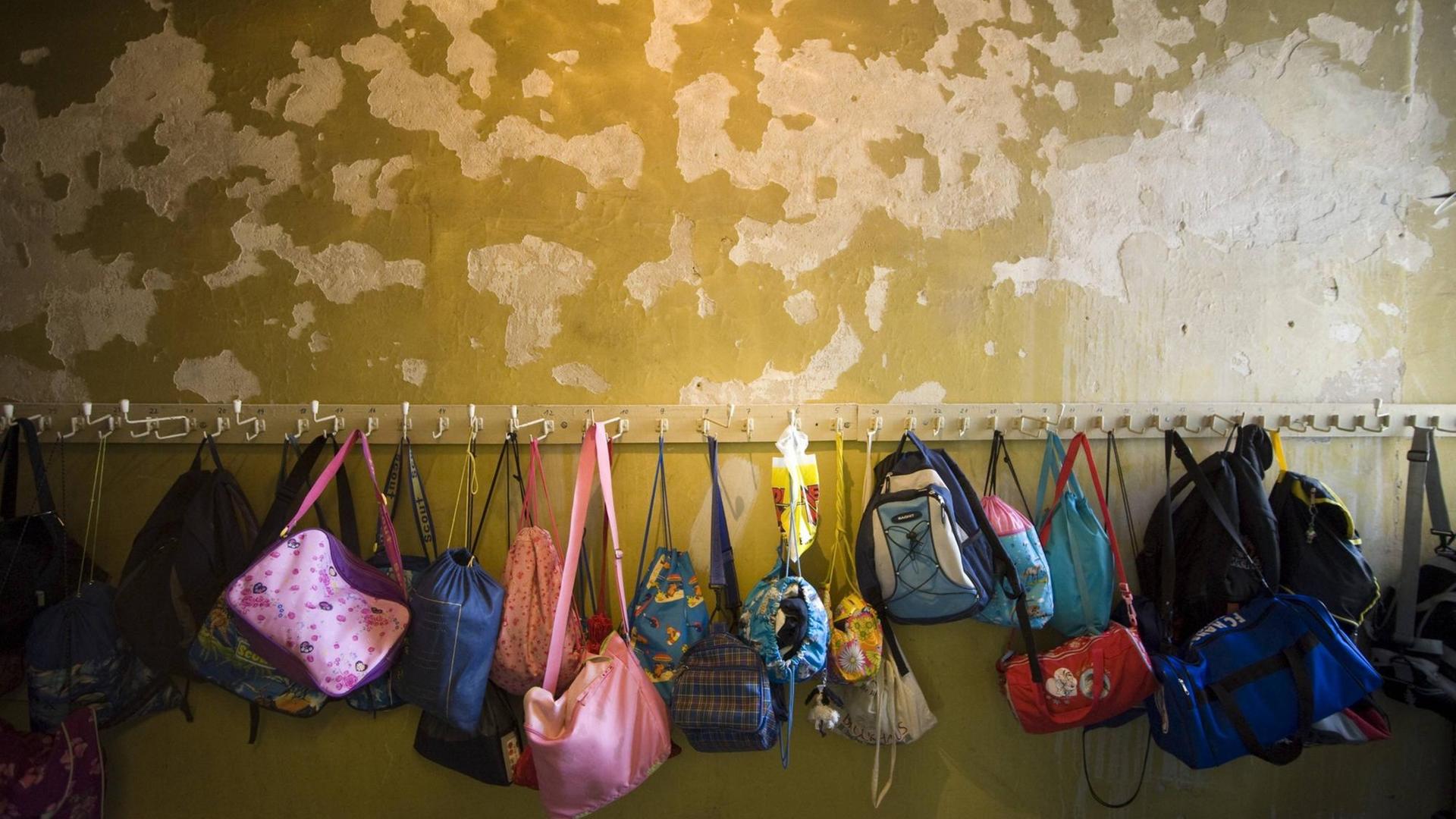 Putzschäden an einer Garderobenwand einer Grundschule