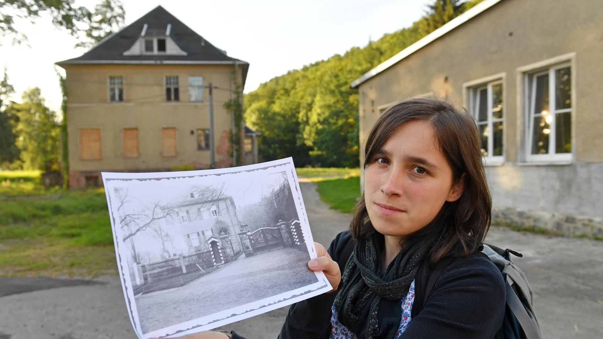 Vor der mittlerweile verfallenen Kommandantenvilla des ehemaligen KZ Sachsenburg in Frankenberg (Sachsen) hält Anna Schüller ein historisches Foto der Villa in ihren Händen. Vor der mittlerweile verfallenen Kommandantenvilla des ehemaligen KZ Sachsenburg in Frankenberg (Sachsen) hält Anna Schüller ein historisches Foto der Villa in ihren Händen.