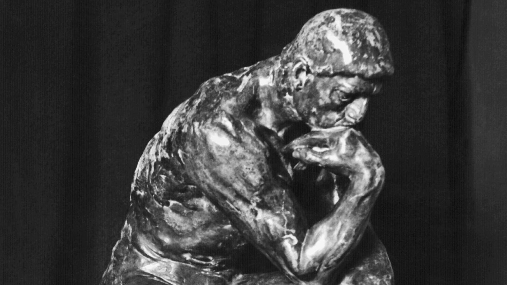 Schwarz-Weiß-Aufnahme der Skulptur "Der Denker" aus dem Jahre 1904 des berühmten französischen Bildhauers, Grafikers und Malers Auguste Rodin 