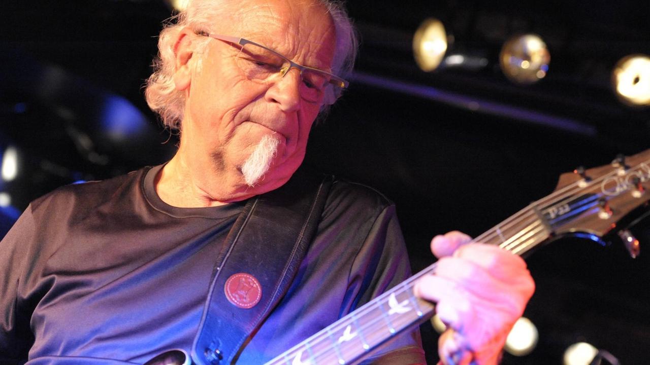 Ein Mann spielt Gitarre auf einer Bühne Ein Mann spielt Gitarre auf einer Bühne