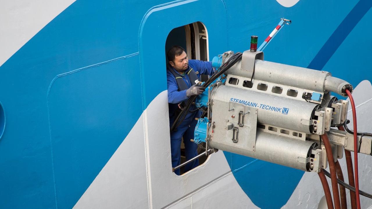 Ein Servicetechniker an Bord des Kreuzfahrtschiffs «Aidasol» nimmt die Starkstromleitungen der Landstromanlage am Cruise Center Altona für ein Stromverbindung an Bord. Durch die Stromversorgung von Schiffen während ihrer Liegezeiten im Hafen soll die Umweltbelastung durch Schiffsdiesel gesenkt werden. 