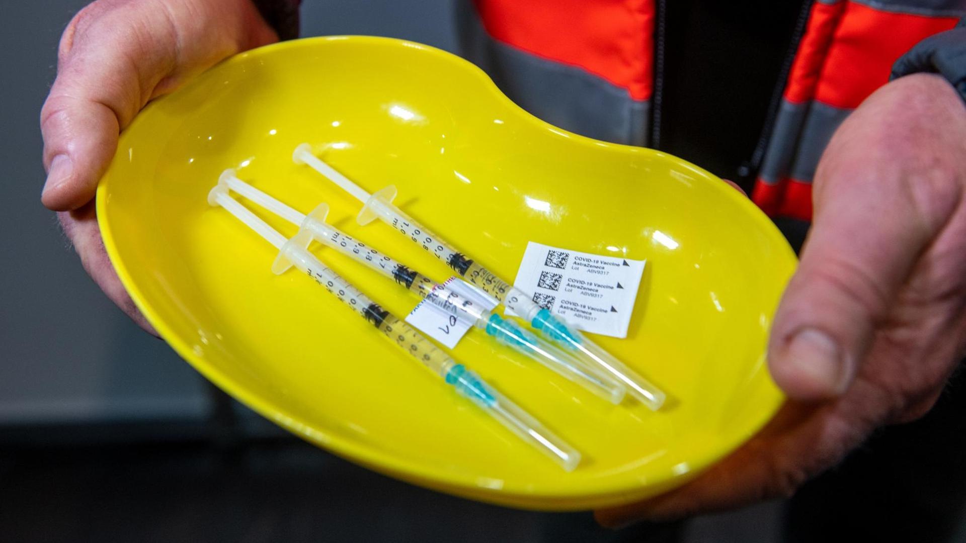 Ein Mitarbeiter des Impzentrums Leipzig hält eine Schale mit drei Spritzen, in denen der Anti-Corona Impfstoff von Astrazeneca aufgezogen ist. Ein Mitarbeiter des Impzentrums Leipzig hält eine Schale mit drei Spritzen, in denen der Anti-Corona Impfstoff von Astrazeneca aufgezogen ist.