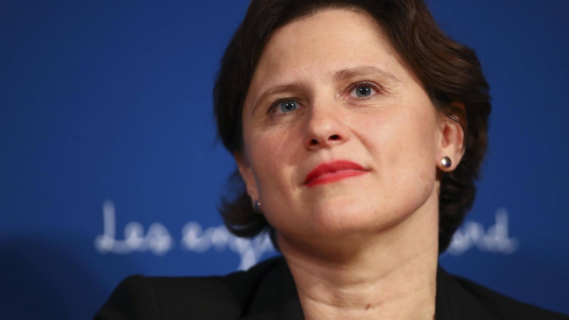 Die französische Sportministerin Roxana Maracineanu sitzt vor einem blauen Hintergrund bei einer Pressekonferenz in Paris. Die französische Sportministerin Roxana Maracineanu sitzt vor einem blauen Hintergrund bei einer Pressekonferenz in Paris.
