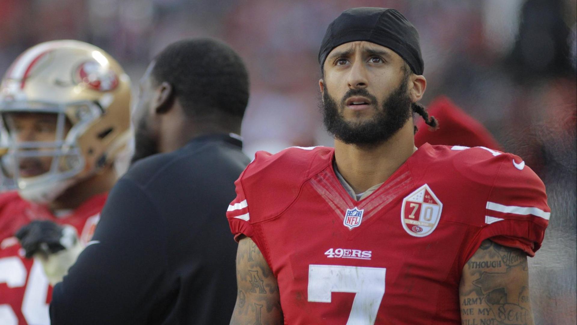 Der Quarterback der San Francisco 49ers, Colin Kaepernick, kniete während der Nationalhymne. Der Quarterback der San Francisco 49ers, Colin Kaepernick, kniete während der Nationalhymne.