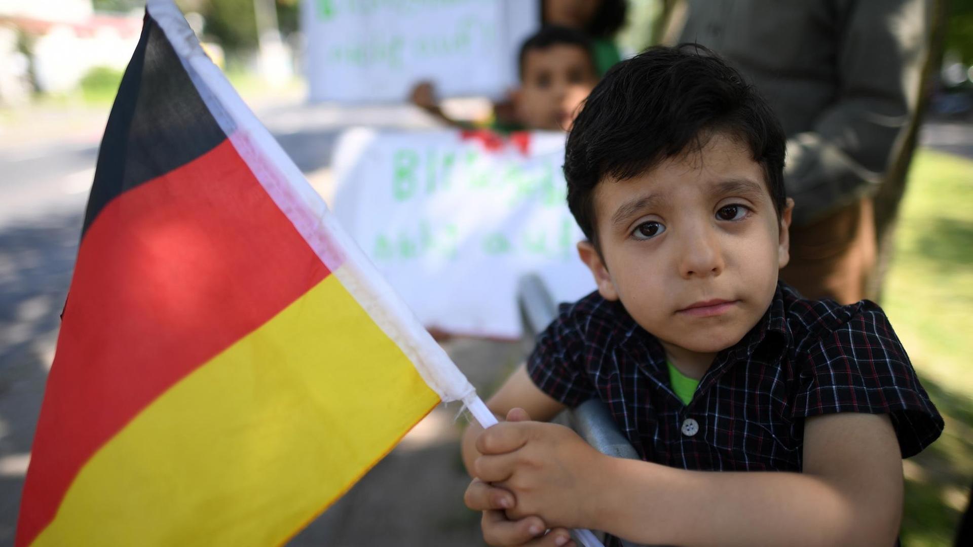 Flüchltingskind mit einer deutschen Flagge Flüchltingskind mit einer deutschen Flagge