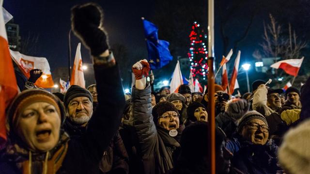 Menschen bei einer Demonstration von Regierungsgegnern in Polen rufen Slogans