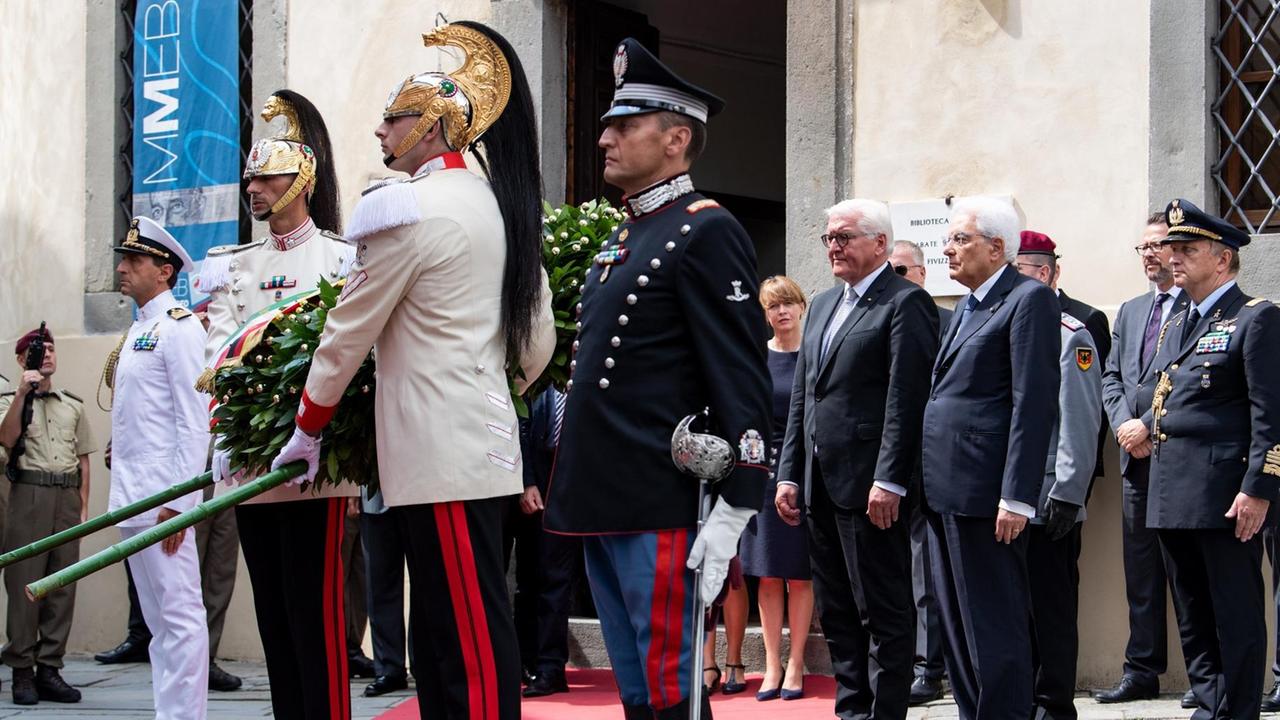 Bundespräsident Steinmeier und der italienische Staatspräsident Mattarella legen an der Gedenktafel für die Opfer der Massaker von Fivizzano gemeinsam einen Kranz nieder.