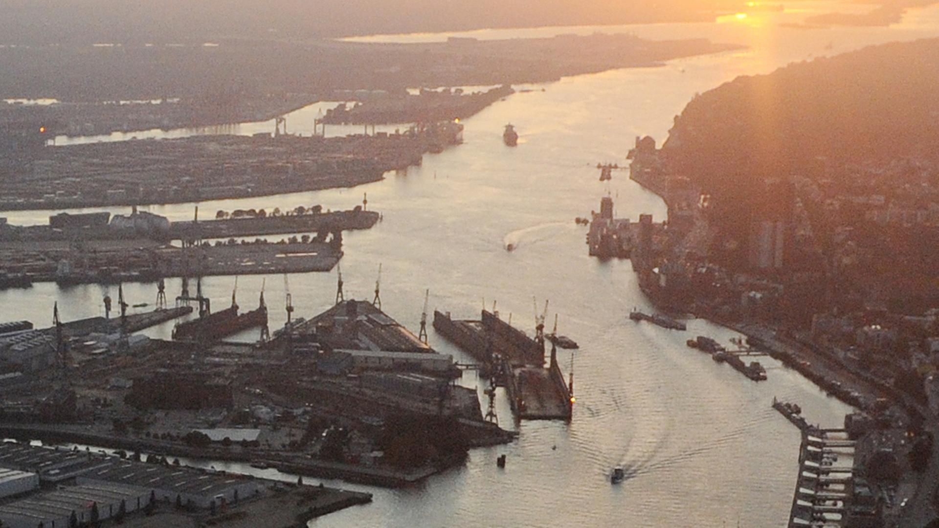 Teile des Hamburger Hafens und die Elbe im Licht der untergehenden Sonne.