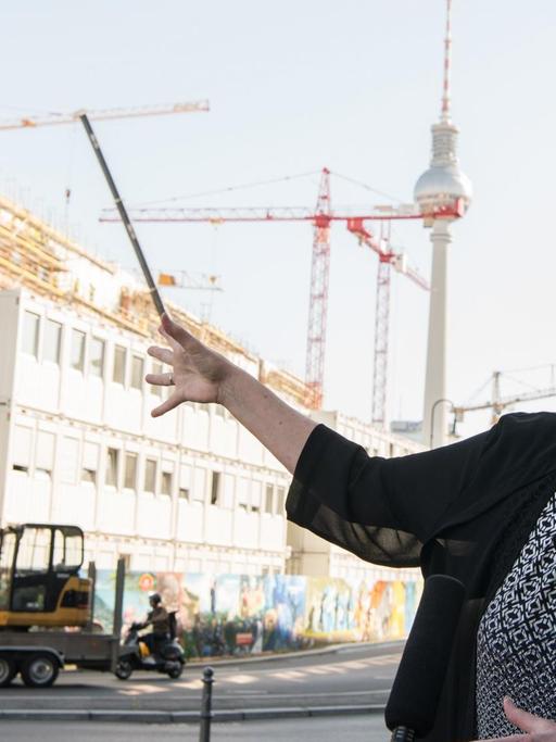 Bundesbauministerin Barbara Hendricks (SPD) deutet bei einem Interview auf die Baustelle des Berliner Schlosses in Berlin.