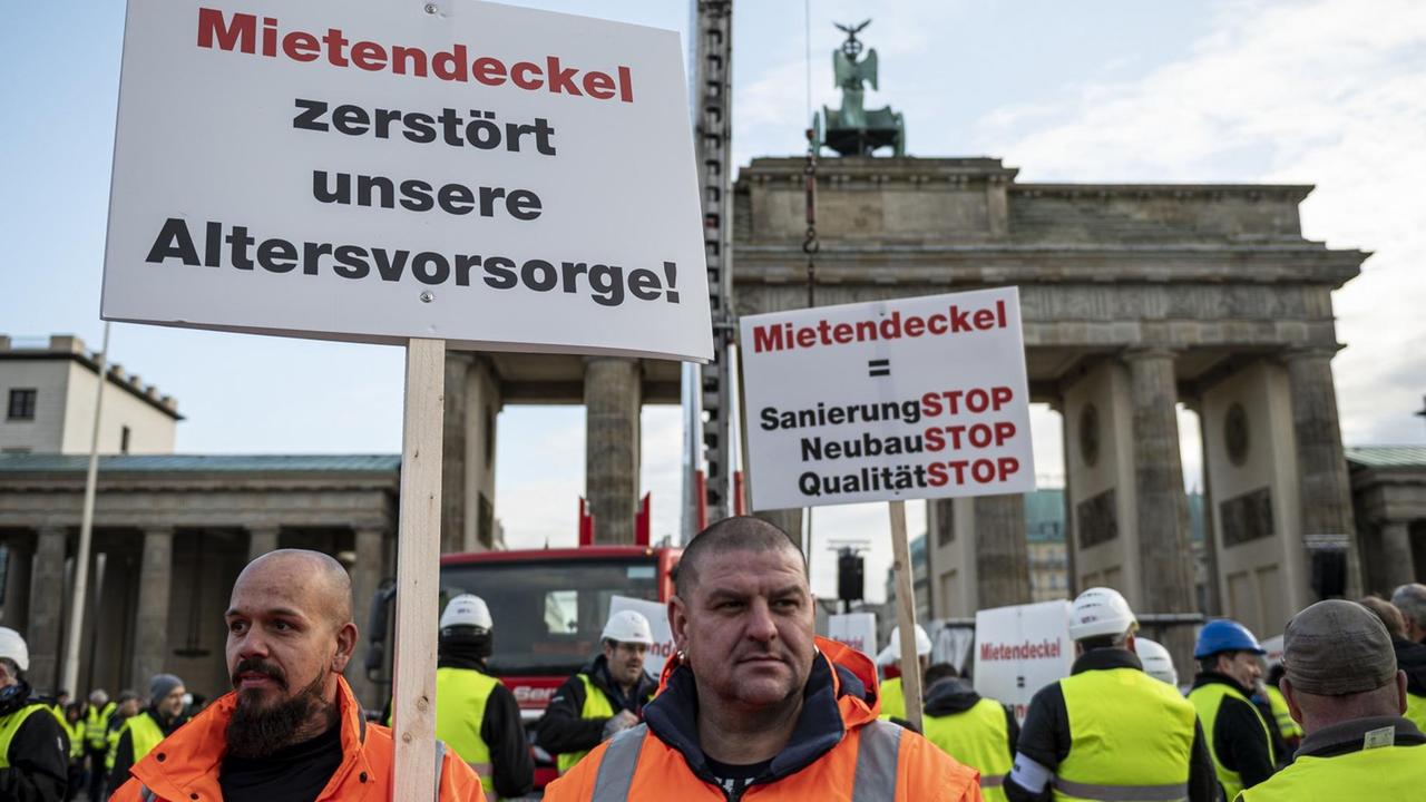 09.12.2019, Berlin: Demonstranten stehen bei einer Kundgebung eines Bündnisses der Berliner Bau- und Wohnungswirtschaft und von Vermietern gegen den Mietendeckel vor dem Brandenburger Tor mit einem Schild mit der Aufschrift "Mietendeckel zerstört unsere Altersvorsorge". Mit dem Mietendeckel will das Land Berlin die Mieten einfrieren und eine Mietobergrenze festlegen. Foto: Fabian Sommer/dpa | Verwendung weltweit 09.12.2019, Berlin: Demonstranten stehen bei einer Kundgebung eines Bündnisses der Berliner Bau- und Wohnungswirtschaft und von Vermietern gegen den Mietendeckel vor dem Brandenburger Tor mit einem Schild mit der Aufschrift "Mietendeckel zerstört unsere Altersvorsorge". Mit dem Mietendeckel will das Land Berlin die Mieten einfrieren und eine Mietobergrenze festlegen. Foto: Fabian Sommer/dpa | Verwendung weltweit