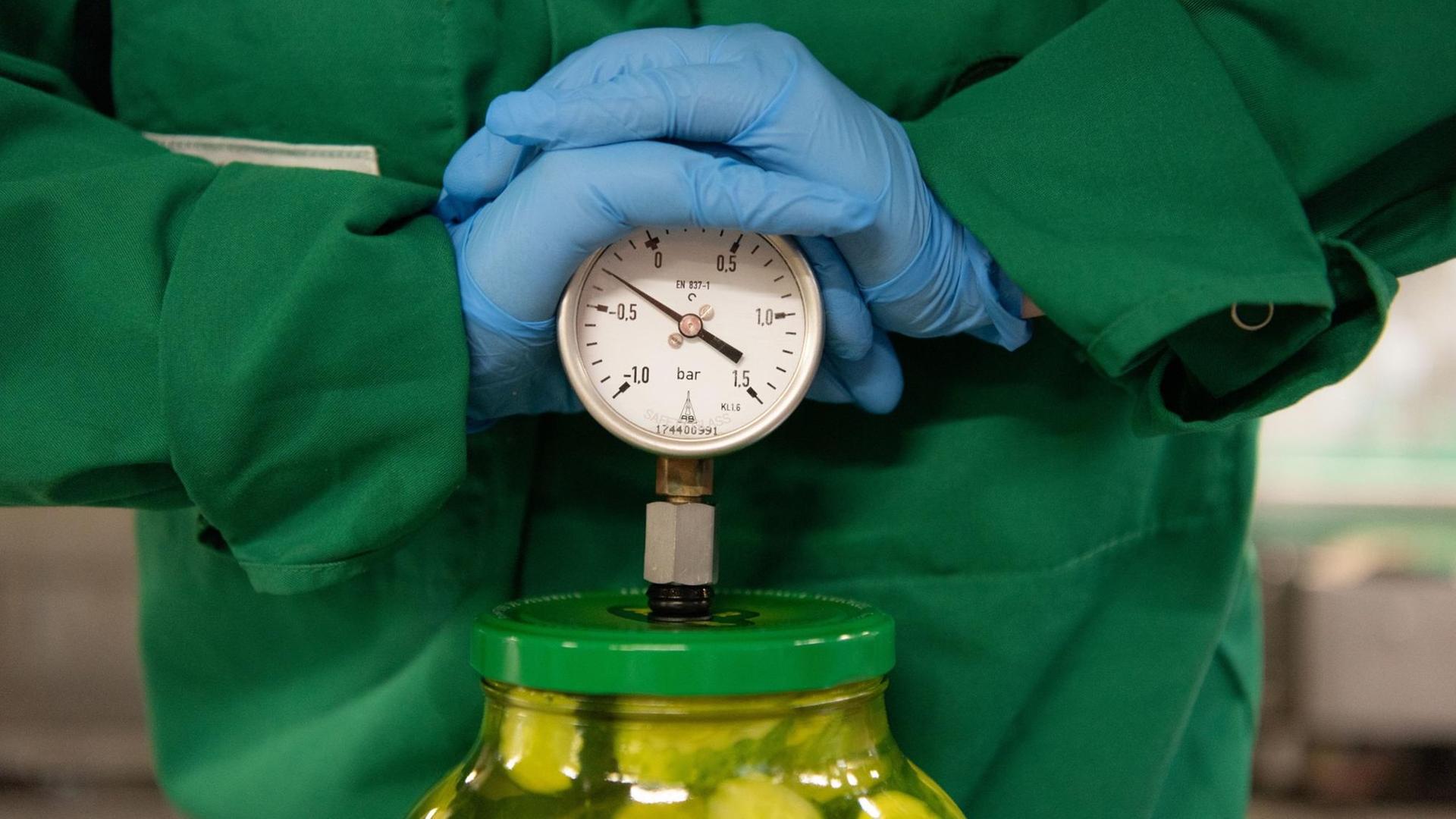 Eine Auszubildende zur Lebensmitteltechnikerin überprüft am 30.07.2019 in einem Gruken-Werk in Schweinfurt das Vakuum innerhalb der Gläser mit Gewürzgurcken Eine Auszubildende zur Lebensmitteltechnikerin überprüft am 30.07.2019 in einem Gruken-Werk in Schweinfurt das Vakuum innerhalb der Gläser mit Gewürzgurcken